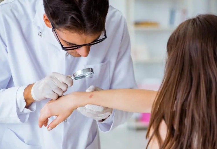 Dr. analisando mancha na pele no possível diagnóstico de câncer